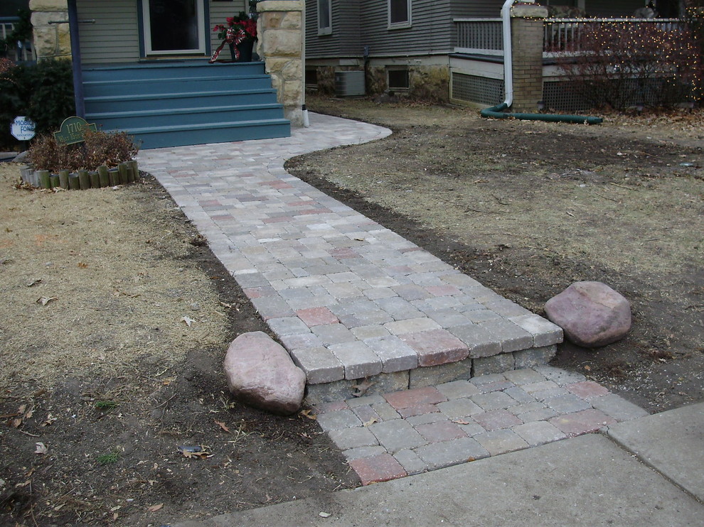 Traditional front yard garden in Other with concrete pavers and with path.