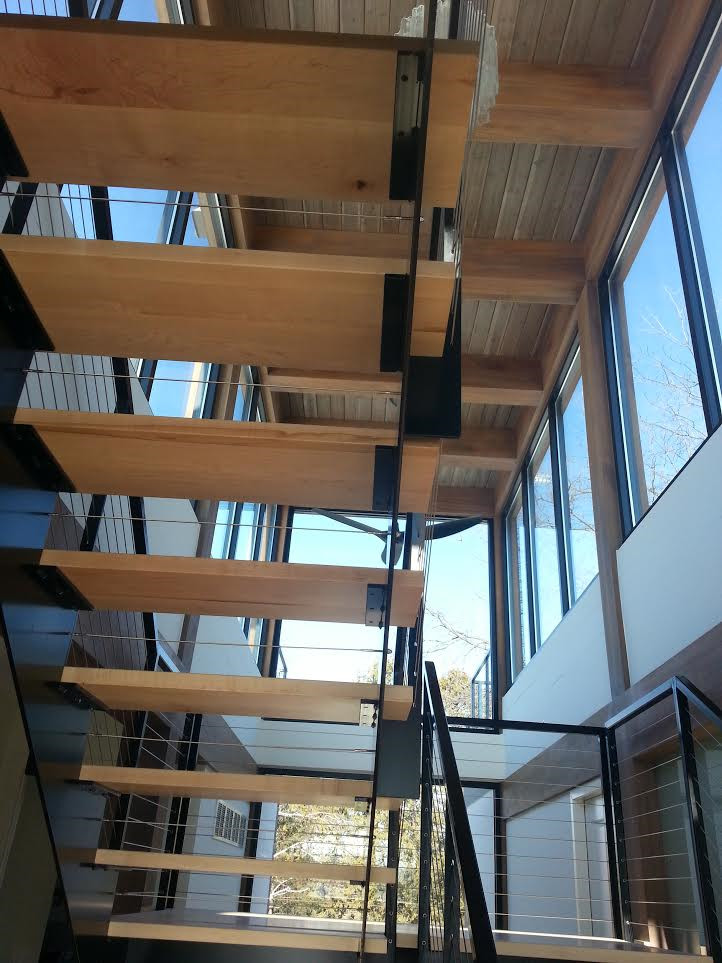 Inspiration for a large contemporary wood floating staircase in Minneapolis with open risers.