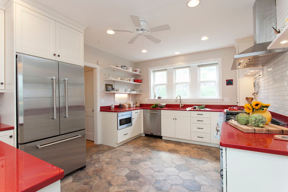 Photo of a scandinavian eat-in kitchen in Bridgeport with an undermount sink, shaker cabinets, white cabinets, quartz benchtops, white splashback, ceramic splashback, stainless steel appliances, porcelain floors, a peninsula and red benchtop.