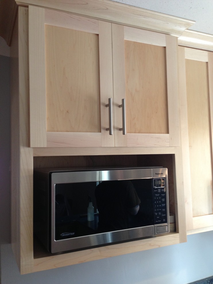 Small transitional u-shaped medium tone wood floor enclosed kitchen photo in Chicago with a double-bowl sink, shaker cabinets, light wood cabinets, quartzite countertops, stainless steel appliances and a peninsula