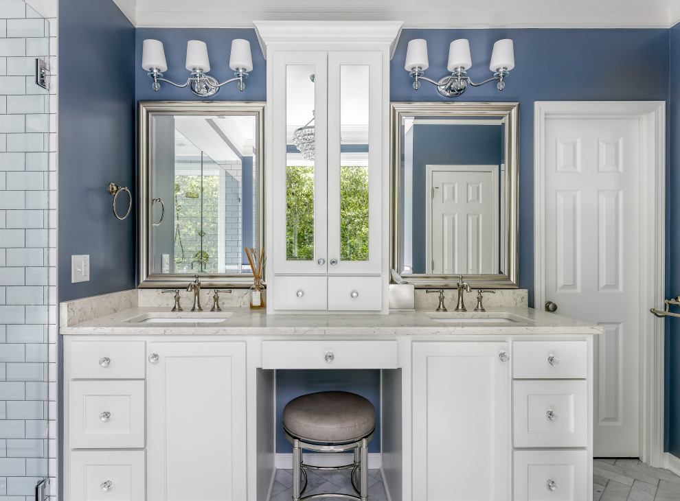 This is an example of a mid-sized modern master bathroom in Kansas City with beaded inset cabinets, white cabinets, a freestanding tub, a curbless shower, a two-piece toilet, white tile, porcelain tile, blue walls, porcelain floors, an undermount sink, engineered quartz benchtops, multi-coloured floor, a hinged shower door, grey benchtops, a double vanity and a built-in vanity.