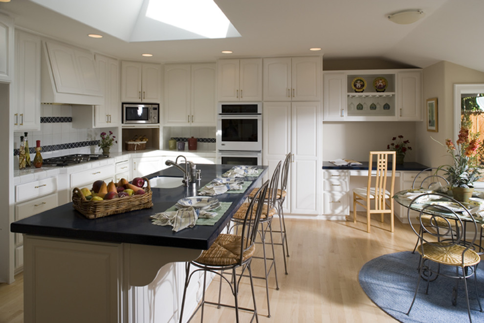 Photo of a traditional eat-in kitchen in San Francisco with raised-panel cabinets and white cabinets.