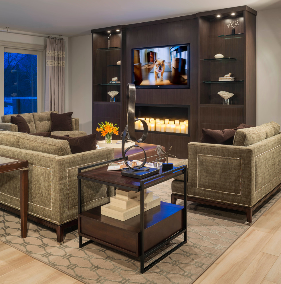 Design ideas for an expansive contemporary open concept family room in Detroit with a built-in media wall, beige walls, a standard fireplace, a wood fireplace surround and light hardwood floors.