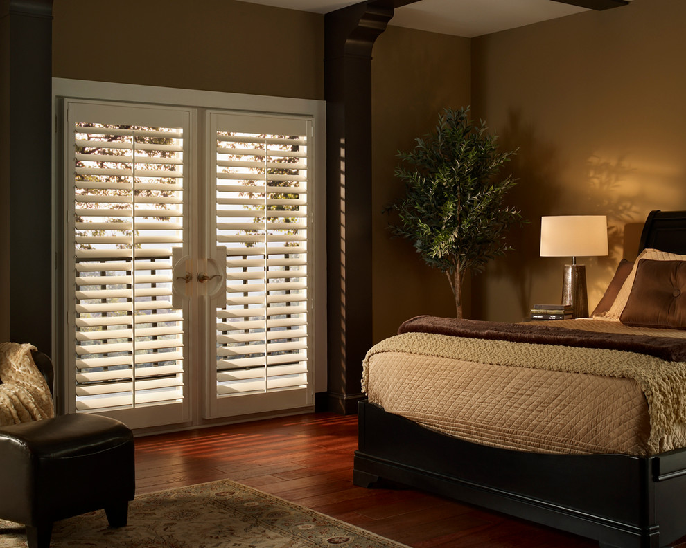 Large mediterranean guest bedroom in Indianapolis with beige walls and medium hardwood floors.