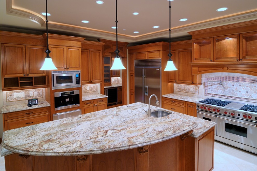 This is an example of a traditional u-shaped open plan kitchen in Tampa with a drop-in sink, raised-panel cabinets, medium wood cabinets, beige splashback, stainless steel appliances and with island.