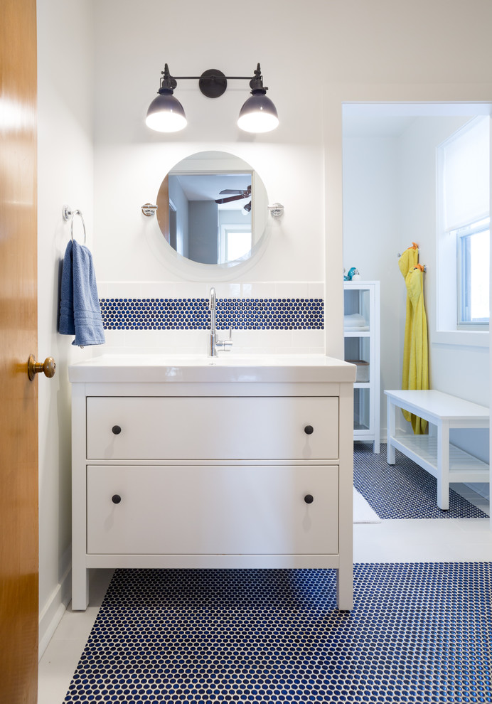 This is an example of a mid-sized transitional kids bathroom in Chicago with furniture-like cabinets, white cabinets, an alcove tub, a shower/bathtub combo, a two-piece toilet, blue tile, ceramic tile, white walls, porcelain floors and a console sink.