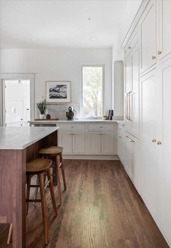 Example of a mid-sized transitional medium tone wood floor and brown floor eat-in kitchen design in Denver with white walls and a standard fireplace