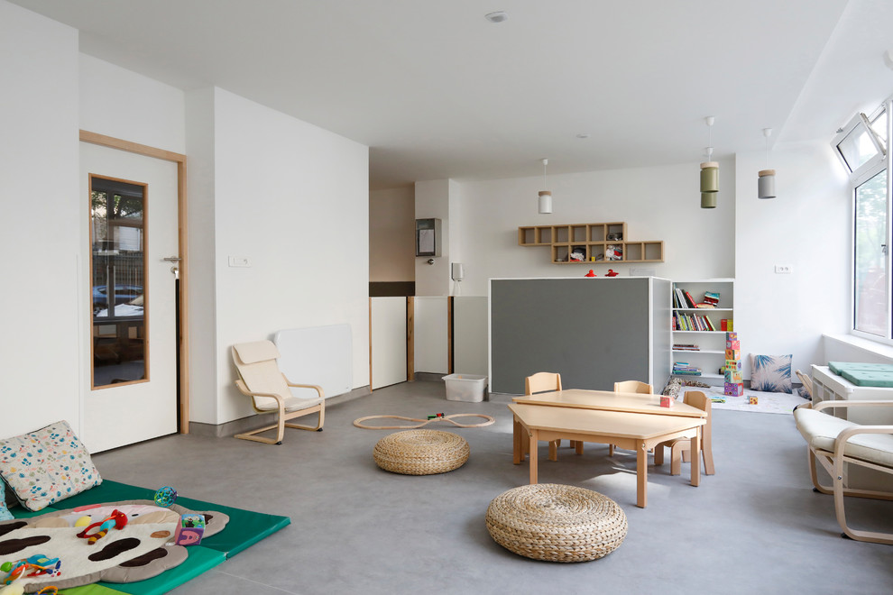 Photo of a scandinavian gender-neutral kids' room in Paris with white walls and grey floor.