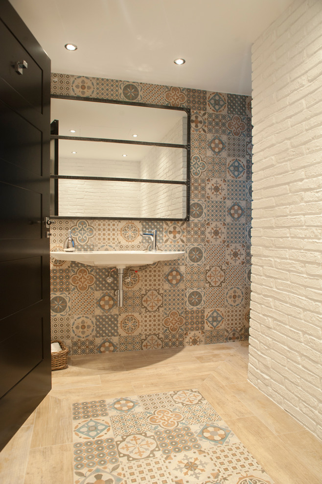 Imagen de aseo nórdico de tamaño medio con sanitario de dos piezas, paredes blancas, suelo de madera clara y lavabo suspendido