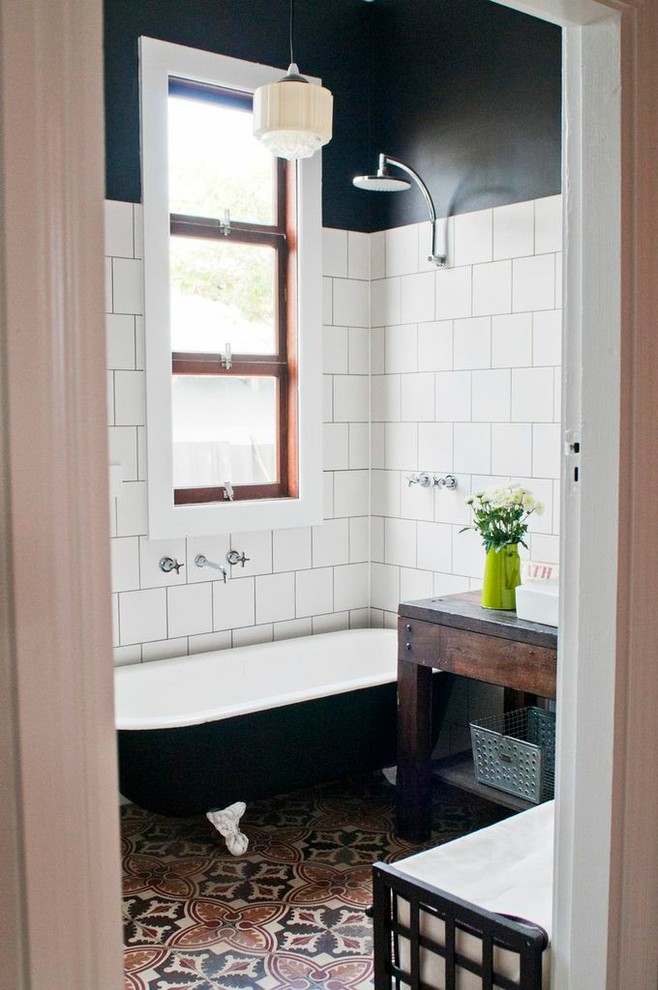 Inspiration for a traditional bathroom in Perth with a claw-foot tub, white tile, black walls, concrete floors, a vessel sink, dark wood cabinets, a shower/bathtub combo, multi-coloured floor and open cabinets.