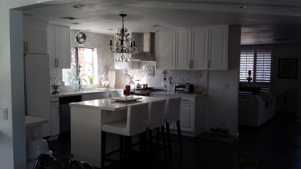 Mid-sized transitional l-shaped dark wood floor open concept kitchen photo with an undermount sink, raised-panel cabinets, white cabinets, quartz countertops, gray backsplash, marble backsplash, paneled appliances and an island