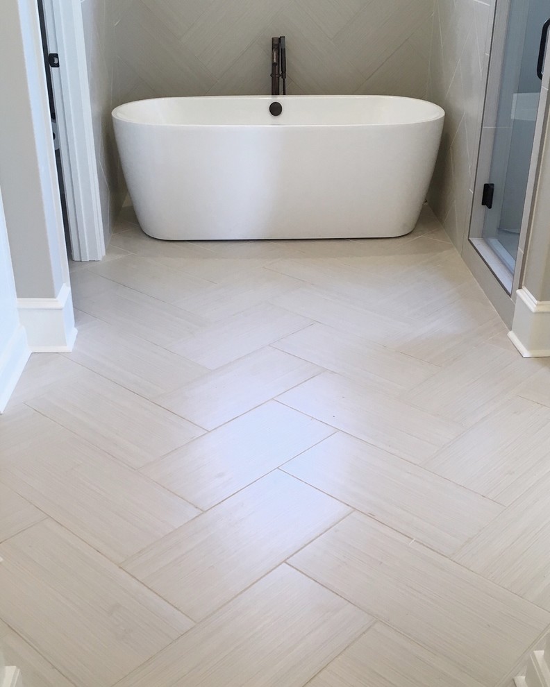 Design ideas for a mid-sized transitional master bathroom in Little Rock with white cabinets, a freestanding tub, an alcove shower, a one-piece toilet, beige tile, porcelain tile, grey walls, porcelain floors, an undermount sink and engineered quartz benchtops.