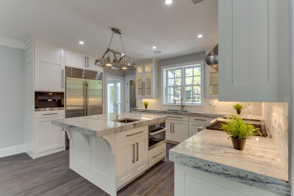Large transitional l-shaped medium tone wood floor open concept kitchen photo in DC Metro with a single-bowl sink, shaker cabinets, white cabinets, marble countertops, white backsplash, porcelain backsplash, stainless steel appliances and an island