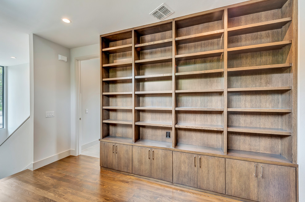 Inspiration for a modern home office in Dallas with white walls, medium hardwood floors and brown floor.