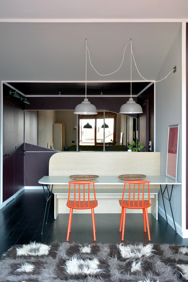 Small contemporary dining room in Turin with white walls and painted wood floors.
