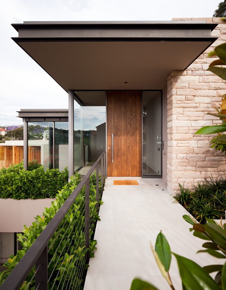 This is an example of a contemporary front door in Sydney with a medium wood front door.