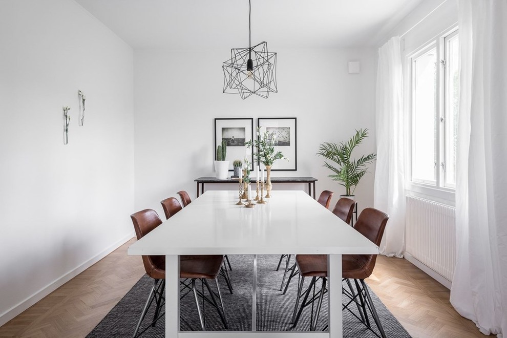 Design ideas for a mid-sized scandinavian separate dining room in Gothenburg with white walls and light hardwood floors.