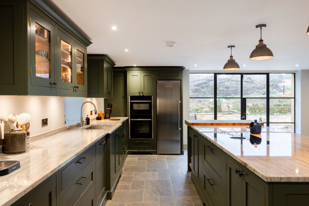 Offene, Große Country Küche in L-Form mit Schrankfronten im Shaker-Stil, grünen Schränken, Granit-Arbeitsplatte und Kücheninsel in Sussex