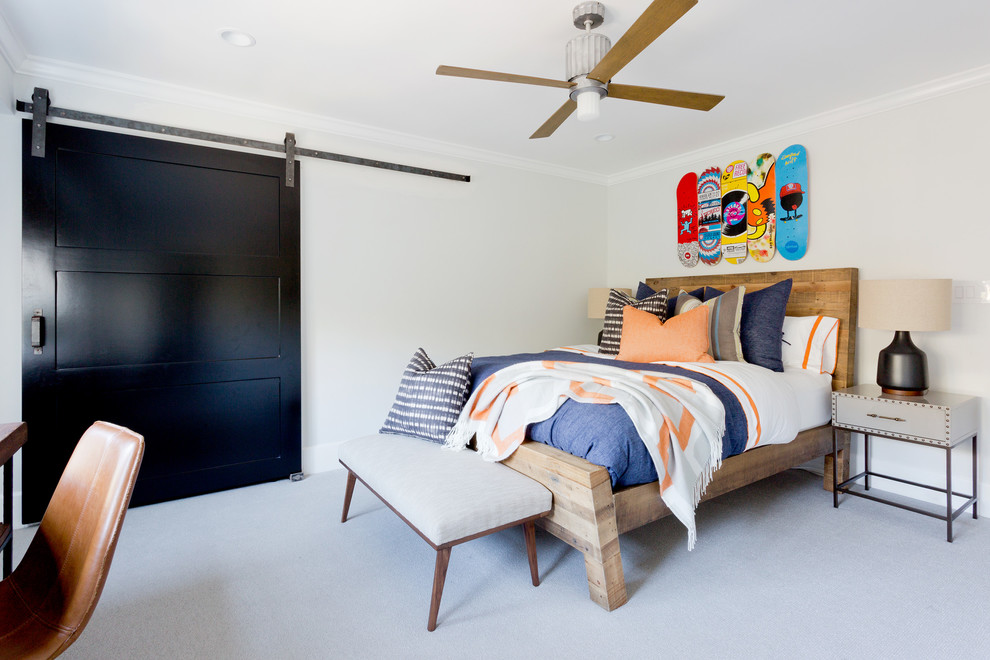 This is an example of a mid-sized transitional kids' bedroom for kids 4-10 years old and boys in Orange County with white walls and carpet.