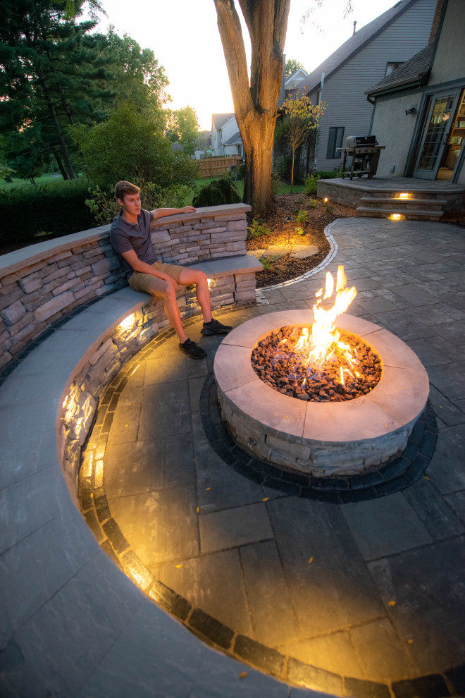 Large elegant backyard stone patio photo in Columbus with a fire pit