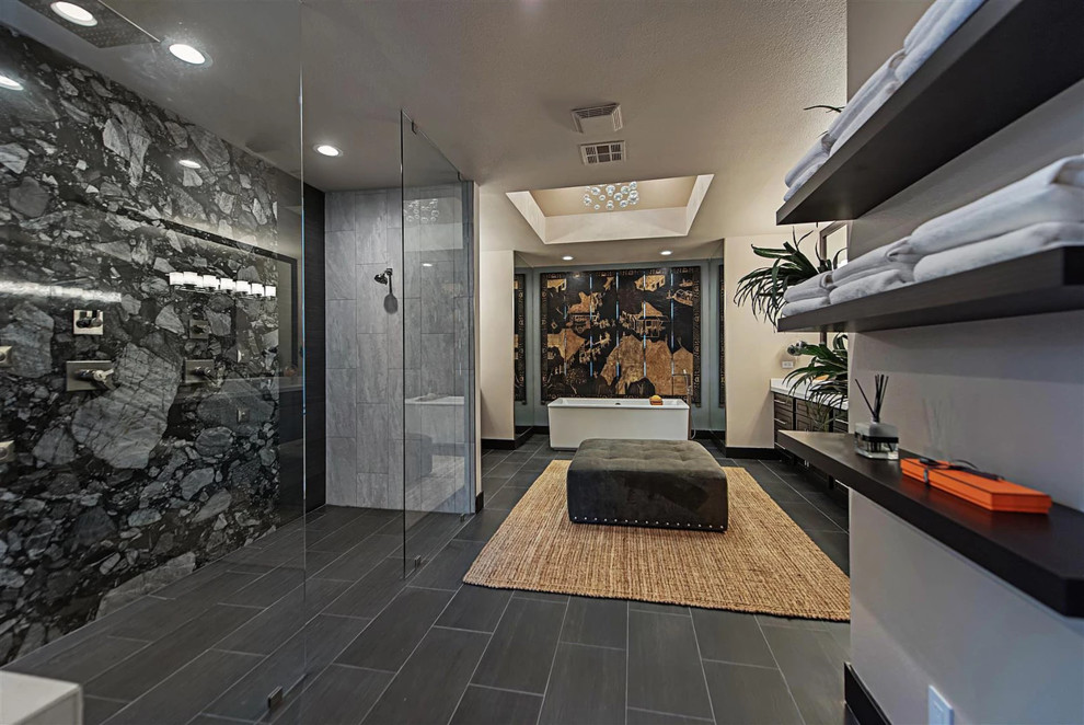 Large asian master bathroom in Las Vegas with flat-panel cabinets, black cabinets, a freestanding tub, an open shower, a one-piece toilet, gray tile, grey walls, granite benchtops, black floor, an open shower, porcelain tile, porcelain floors, a vessel sink and white benchtops.