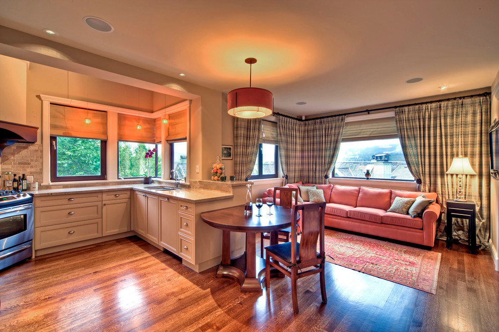 Example of a large transitional l-shaped medium tone wood floor and brown floor eat-in kitchen design with a double-bowl sink, gray backsplash, recessed-panel cabinets, beige cabinets, subway tile backsplash, stainless steel appliances and a peninsula