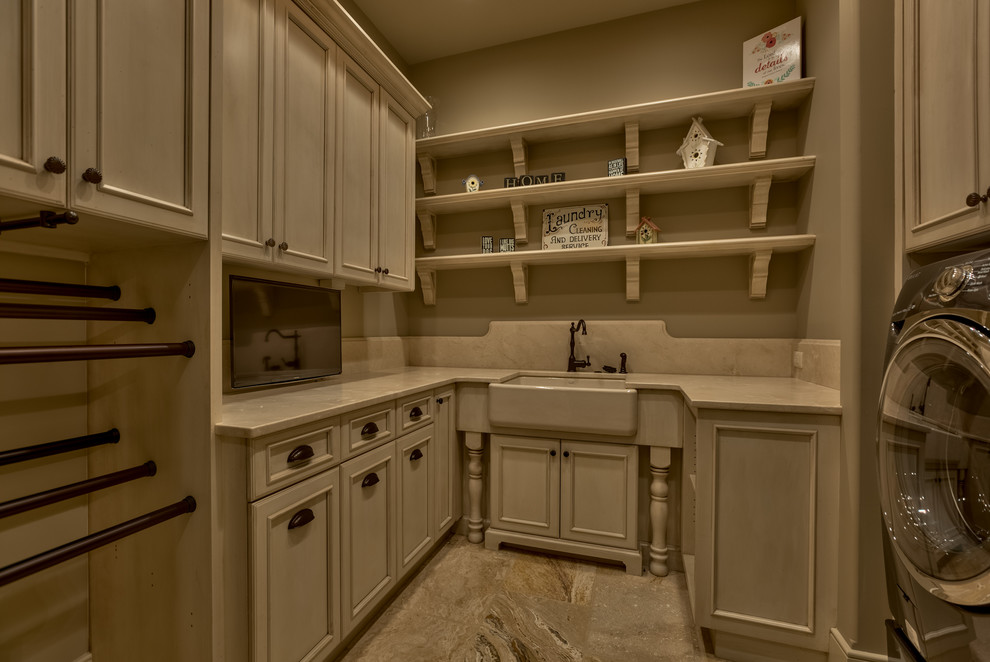 Photo of a mid-sized traditional u-shaped dedicated laundry room in Omaha with a farmhouse sink, recessed-panel cabinets, white cabinets and a side-by-side washer and dryer.