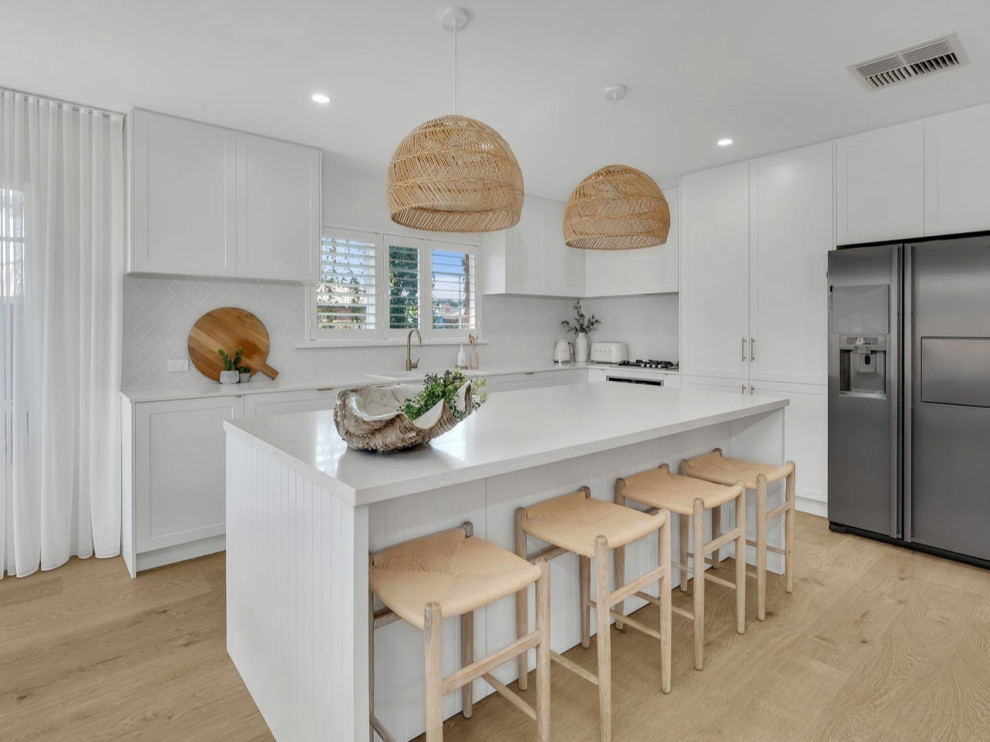 Inspiration for a small traditional galley eat-in kitchen in Melbourne with a double-bowl sink, shaker cabinets, white cabinets, quartz benchtops, white splashback, ceramic splashback, laminate floors, with island and white benchtop.