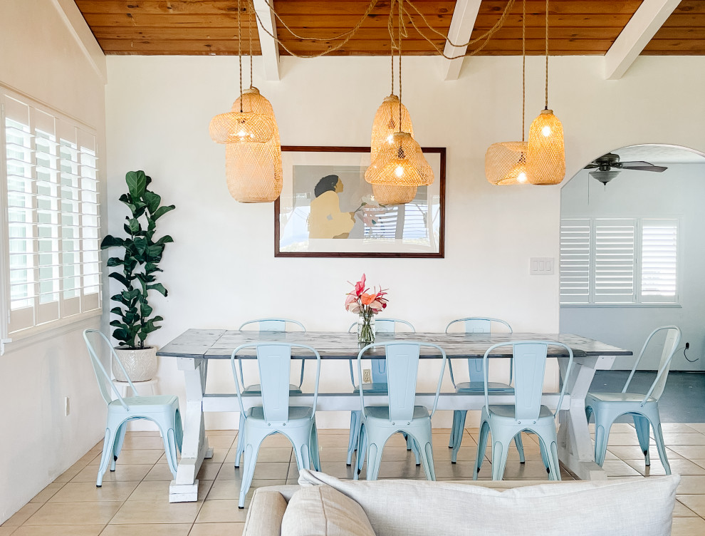 Ispirazione per una sala da pranzo costiera di medie dimensioni con pareti bianche, pavimento con piastrelle in ceramica, pavimento beige e travi a vista