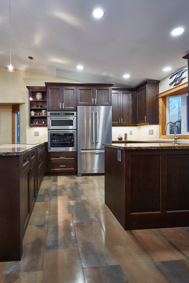 Eat-in kitchen - mid-sized transitional u-shaped porcelain tile eat-in kitchen idea with an undermount sink, shaker cabinets, dark wood cabinets, quartz countertops, beige backsplash, stone tile backsplash, stainless steel appliances and a peninsula