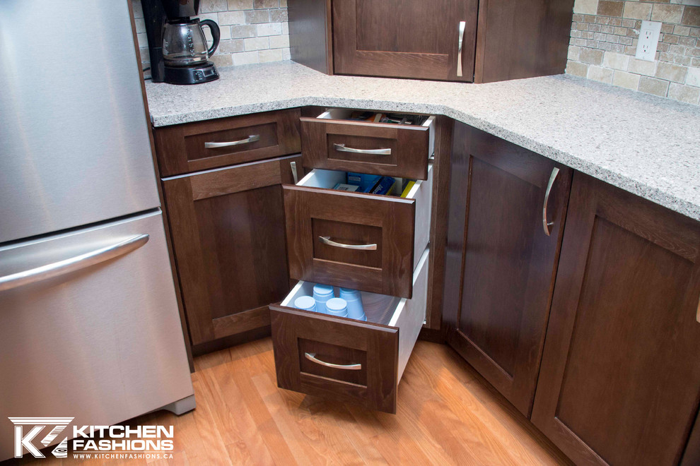 Large transitional u-shaped medium tone wood floor open concept kitchen photo with a farmhouse sink, shaker cabinets, dark wood cabinets, quartz countertops, brown backsplash, stone tile backsplash, stainless steel appliances and an island