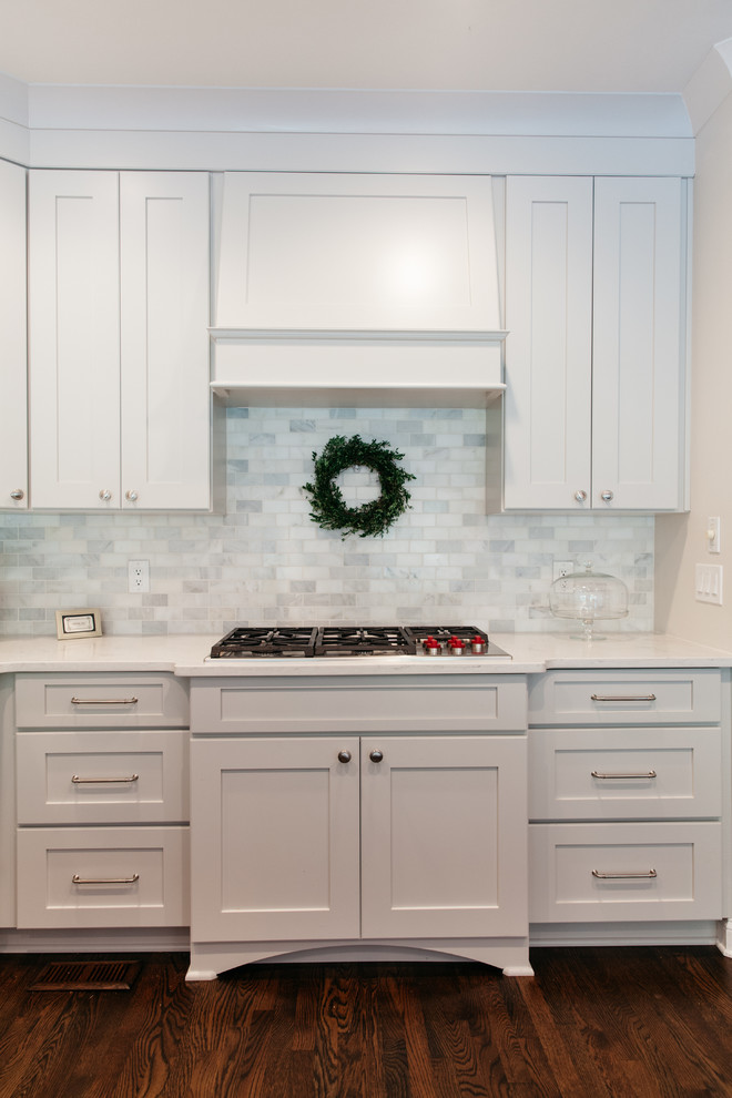 Photo of a transitional kitchen in Nashville with recessed-panel cabinets, grey cabinets, quartz benchtops, white splashback and marble splashback.