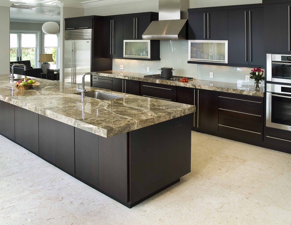 This is an example of a contemporary galley kitchen in Wilmington with stainless steel appliances, an undermount sink, flat-panel cabinets, dark wood cabinets and glass sheet splashback.