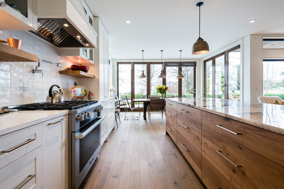 Large contemporary l-shaped open plan kitchen in Vancouver with shaker cabinets, white cabinets, marble benchtops, medium hardwood floors, with island, green floor and turquoise benchtop.