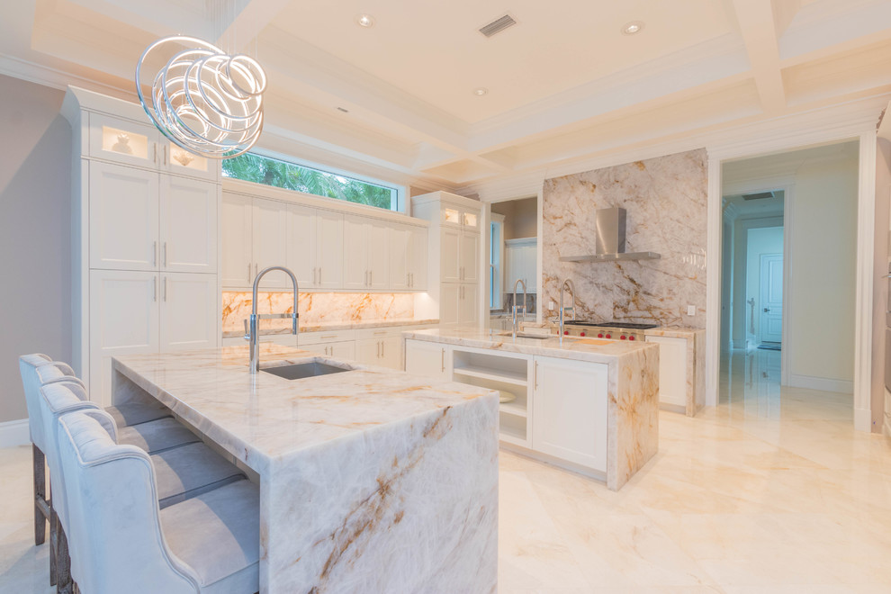 Huge transitional u-shaped marble floor and white floor open concept kitchen photo with an undermount sink, flat-panel cabinets, white cabinets, quartzite countertops, white backsplash, stone slab backsplash and two islands