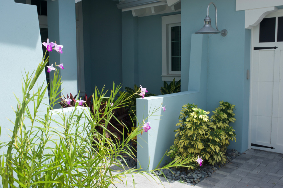 Inspiration for a mid-sized tropical front yard full sun driveway in Miami with concrete pavers.