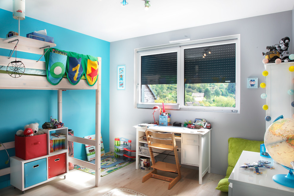 This is an example of a mid-sized traditional kids' bedroom for kids 4-10 years old and boys in Dijon with multi-coloured walls and light hardwood floors.