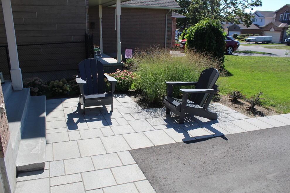 Design ideas for a large contemporary front yard patio in Ottawa with brick pavers.