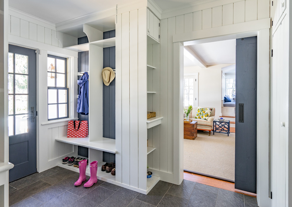 This is an example of a mid-sized country mudroom in Boston with white walls, slate floors, a single front door and a blue front door.