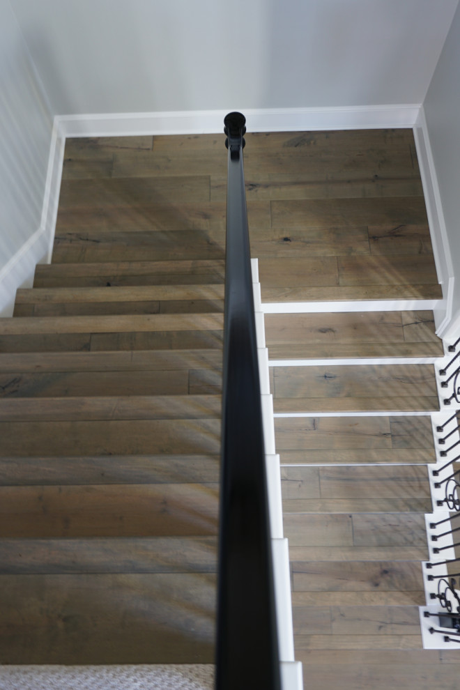 Photo of a country wood u-shaped staircase in San Diego with wood risers and wood railing.