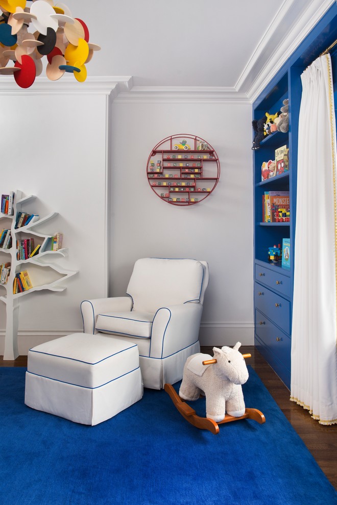 This is an example of an eclectic gender-neutral nursery in Boston with white walls, medium hardwood floors and blue floor.