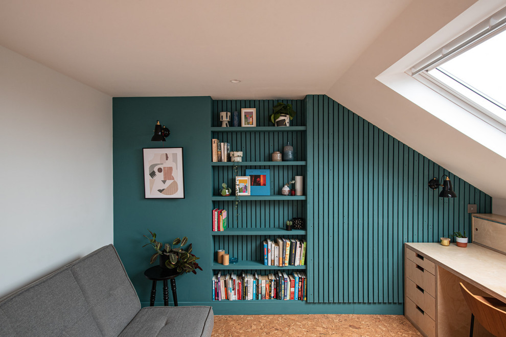 This is an example of a mid-sized scandinavian study room in London with blue walls, cork floors, a built-in desk, brown floor and panelled walls.
