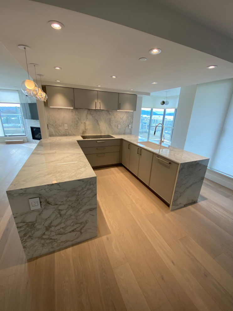 Inspiration for a large modern u-shaped eat-in kitchen in Vancouver with an undermount sink, grey cabinets, quartz benchtops, white splashback, engineered quartz splashback, panelled appliances, light hardwood floors, a peninsula, brown floor and white benchtop.