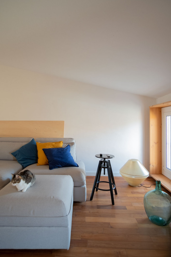 Mittelgroßes Modernes Arbeitszimmer mit Arbeitsplatz, weißer Wandfarbe, braunem Holzboden, freistehendem Schreibtisch, braunem Boden und Holzwänden in Barcelona