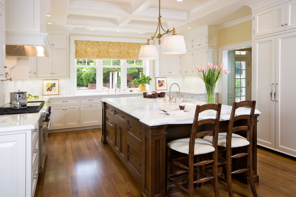 Design ideas for a large traditional u-shaped separate kitchen in San Francisco with beaded inset cabinets, white cabinets, marble benchtops, white splashback, panelled appliances, a farmhouse sink, medium hardwood floors, with island, marble splashback and brown floor.