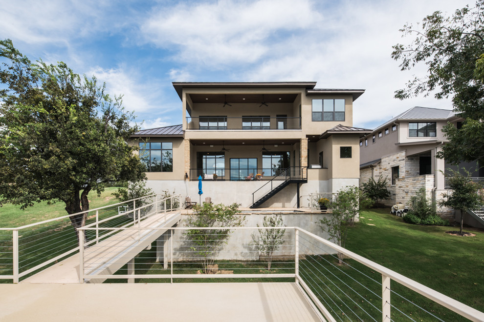 Inspiration for a large transitional backyard stone patio remodel in Austin with a roof extension