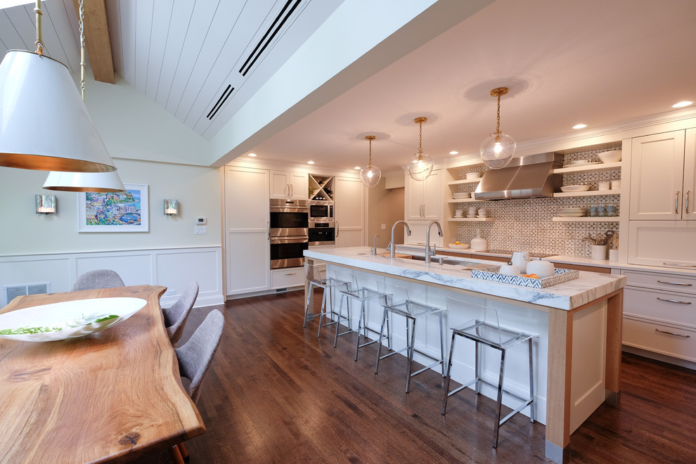 Eat-in kitchen - mid-sized transitional u-shaped medium tone wood floor eat-in kitchen idea in Chicago with an undermount sink, shaker cabinets, white cabinets, marble countertops, multicolored backsplash, ceramic backsplash, paneled appliances and an island