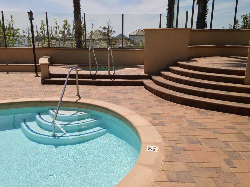 Inspiration for a backyard concrete paver and round pool house remodel in Orange County