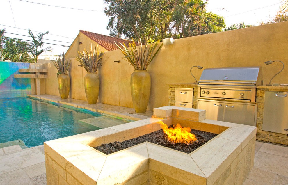 Photo of a large mediterranean backyard rectangular aboveground pool in Los Angeles with a water feature and tile.
