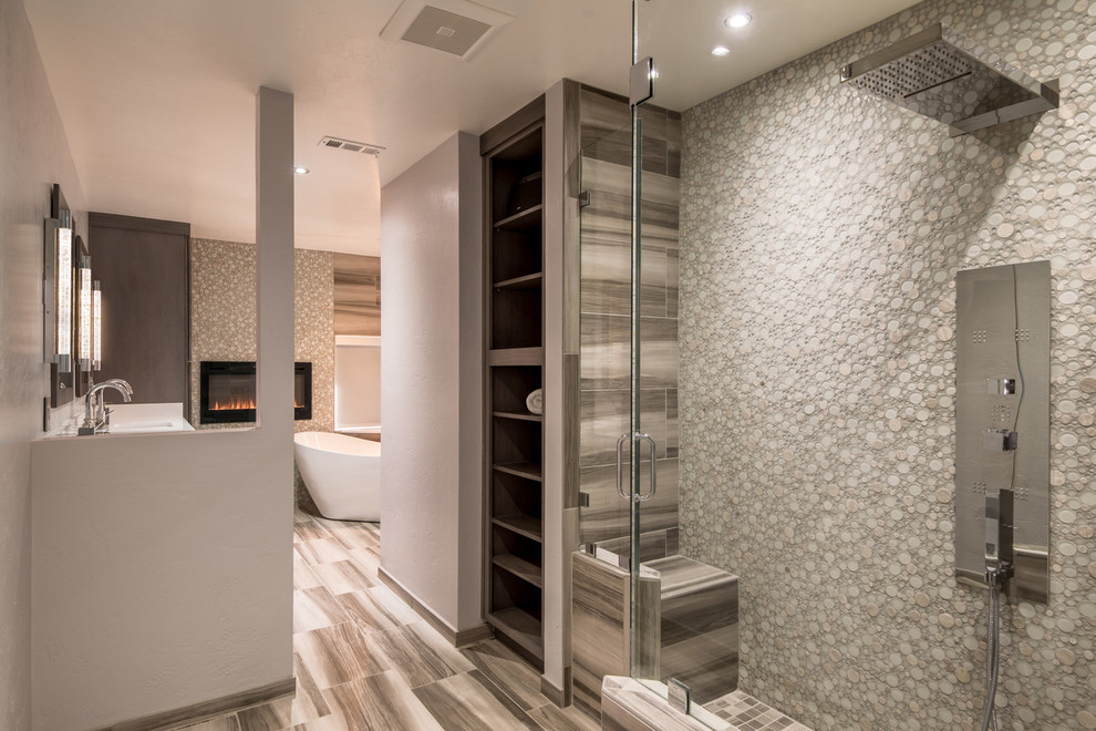 This is an example of a large contemporary master bathroom in San Diego with raised-panel cabinets, brown cabinets, a freestanding tub, a corner shower, a two-piece toilet, gray tile, ceramic tile, grey walls, ceramic floors, an undermount sink, engineered quartz benchtops, grey floor and a hinged shower door.